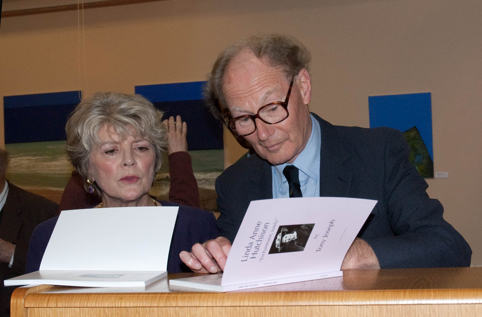 Woman and man look at book together with front cover open