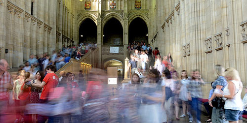 Visitors being directed by student tour guides in red university t-shirts inside the historic Wills building.