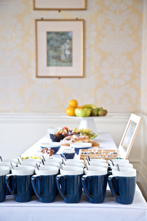 A table set with mugs ready for a refreshment break