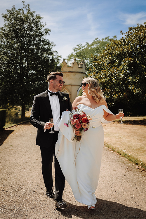 Two people looking at each other. The lady is wearing a wedding dress and the man is wearing a tuxedo